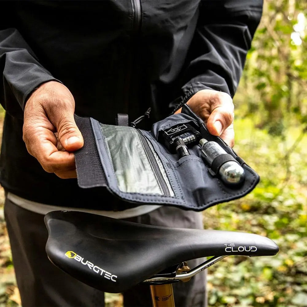 A rider showing the contents of their tool wallet