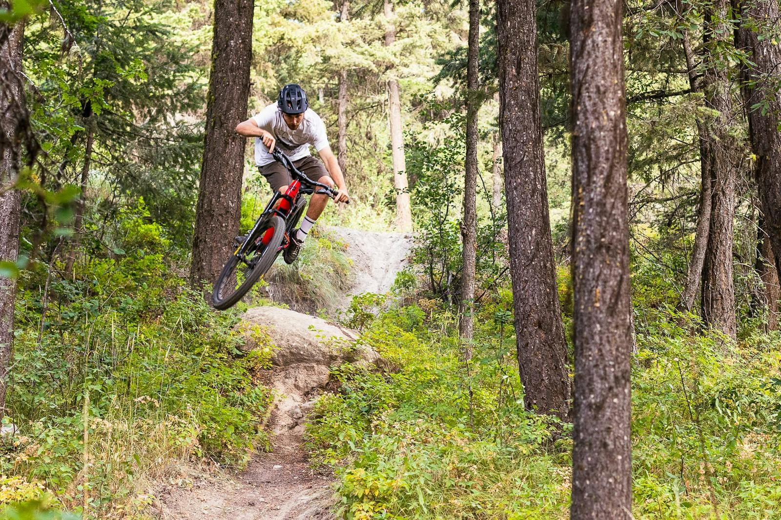 A rider hopping over a rock feature on a 5010