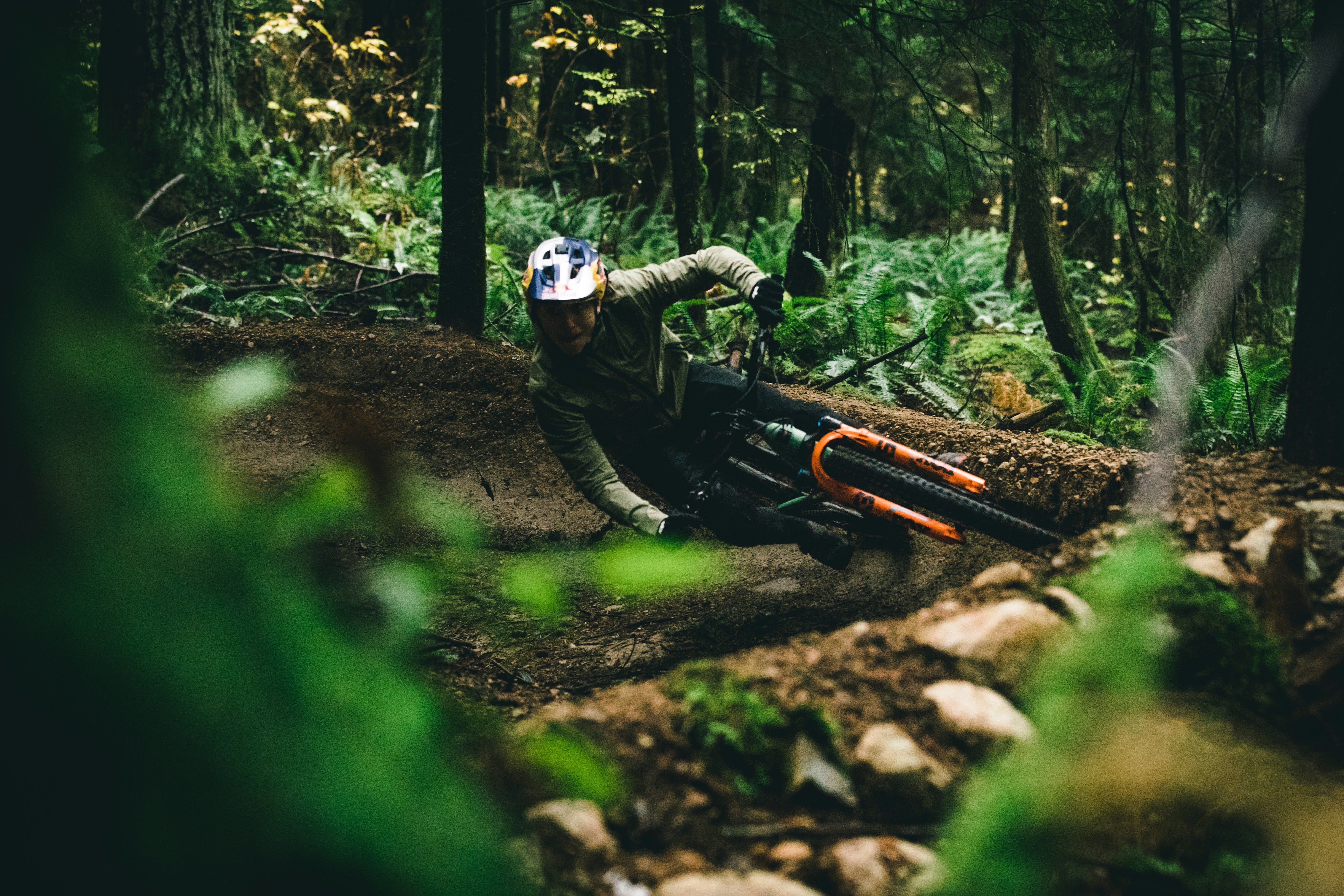 Jackson Goldstone riding a berm on a 5010 in a lush green forest