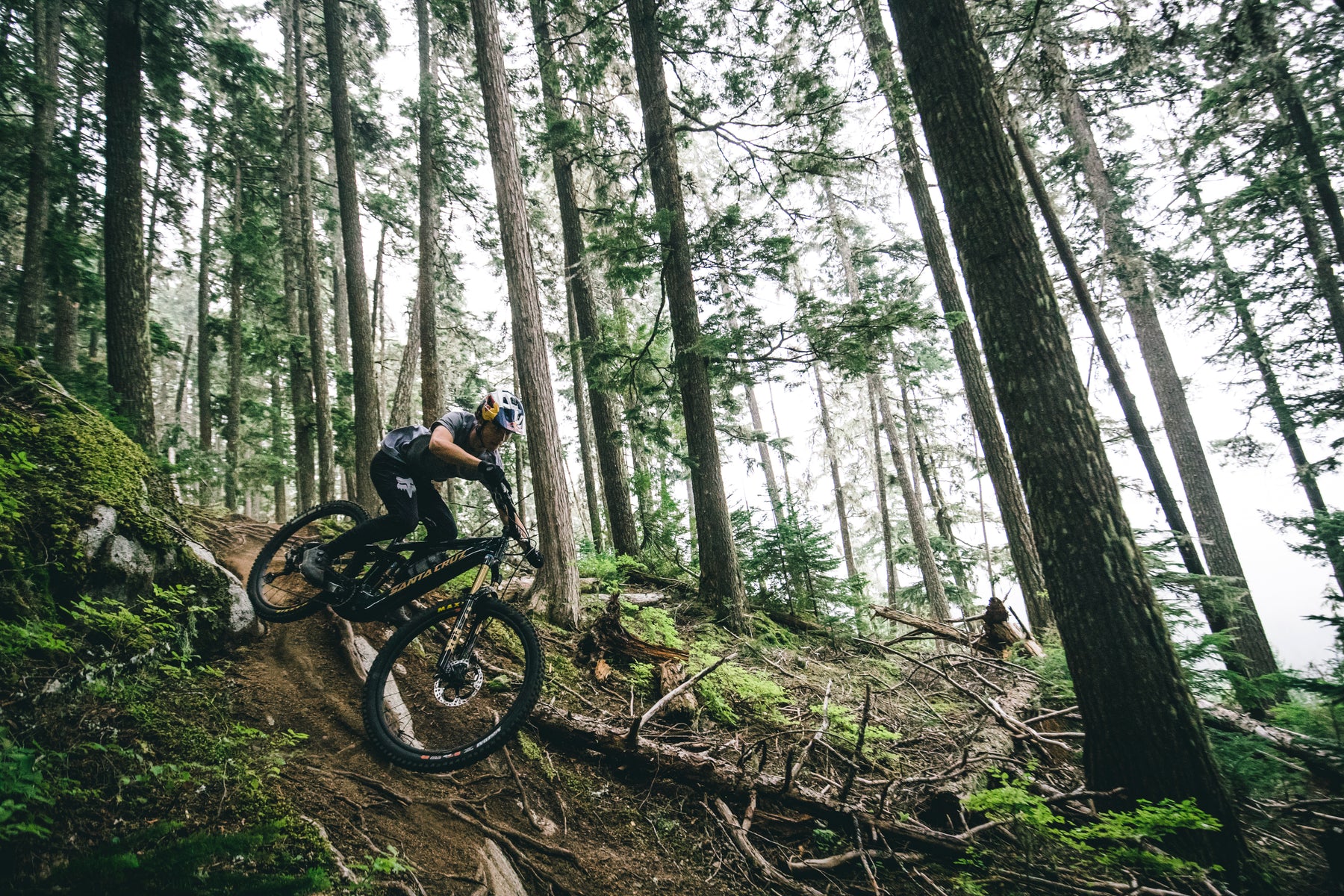 Jackson Goldstone riding a Santa Cruz Vala down a technical trail in the forest