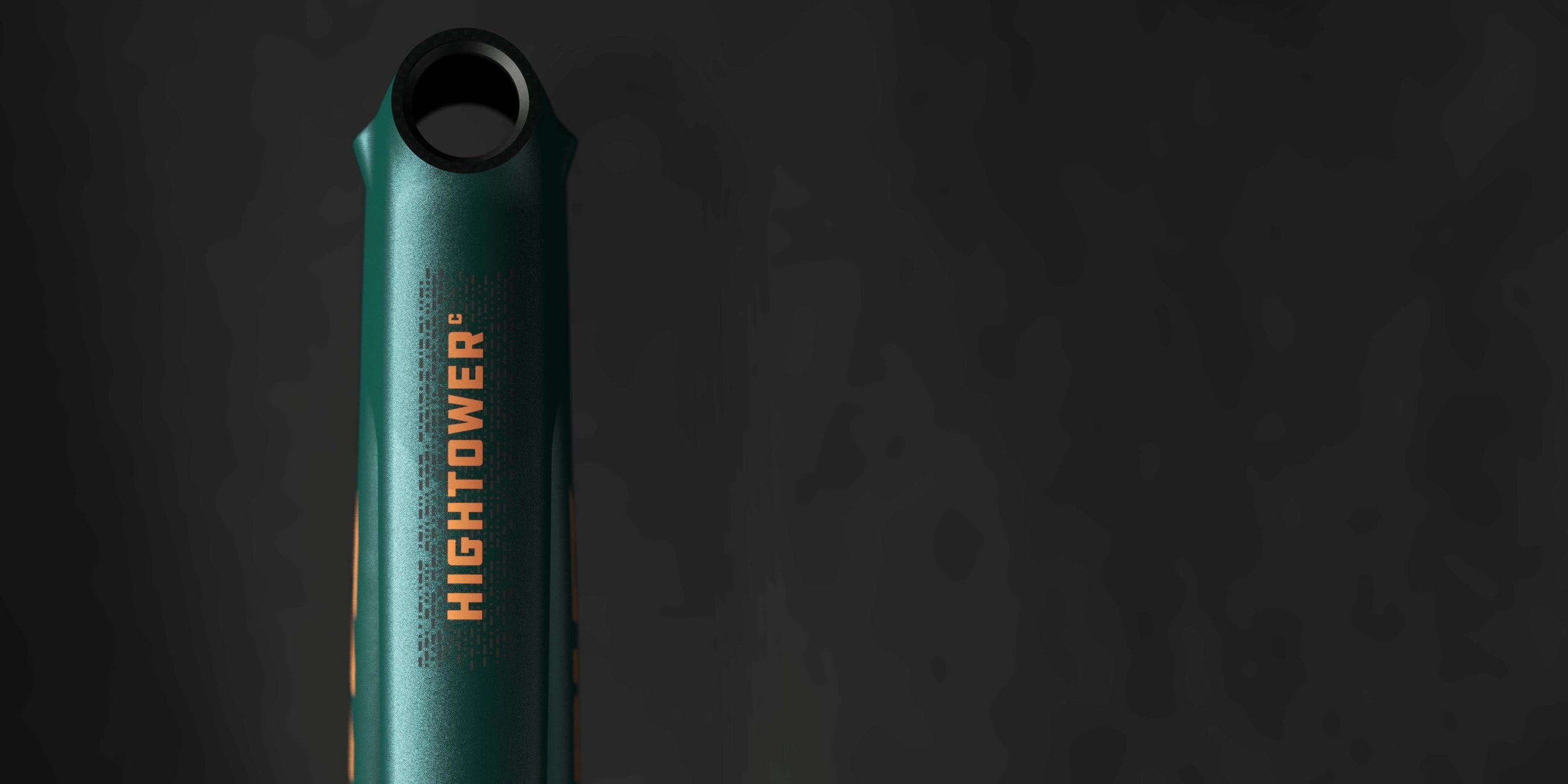 A close-up view of a green bike frame with the "HIGHTOWER" logo in bold orange text, set against a dark background