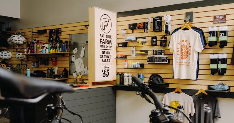 Fat Tire Farm MTB shop interior featuring bike gear, apparel, and a welcoming display for demo and services