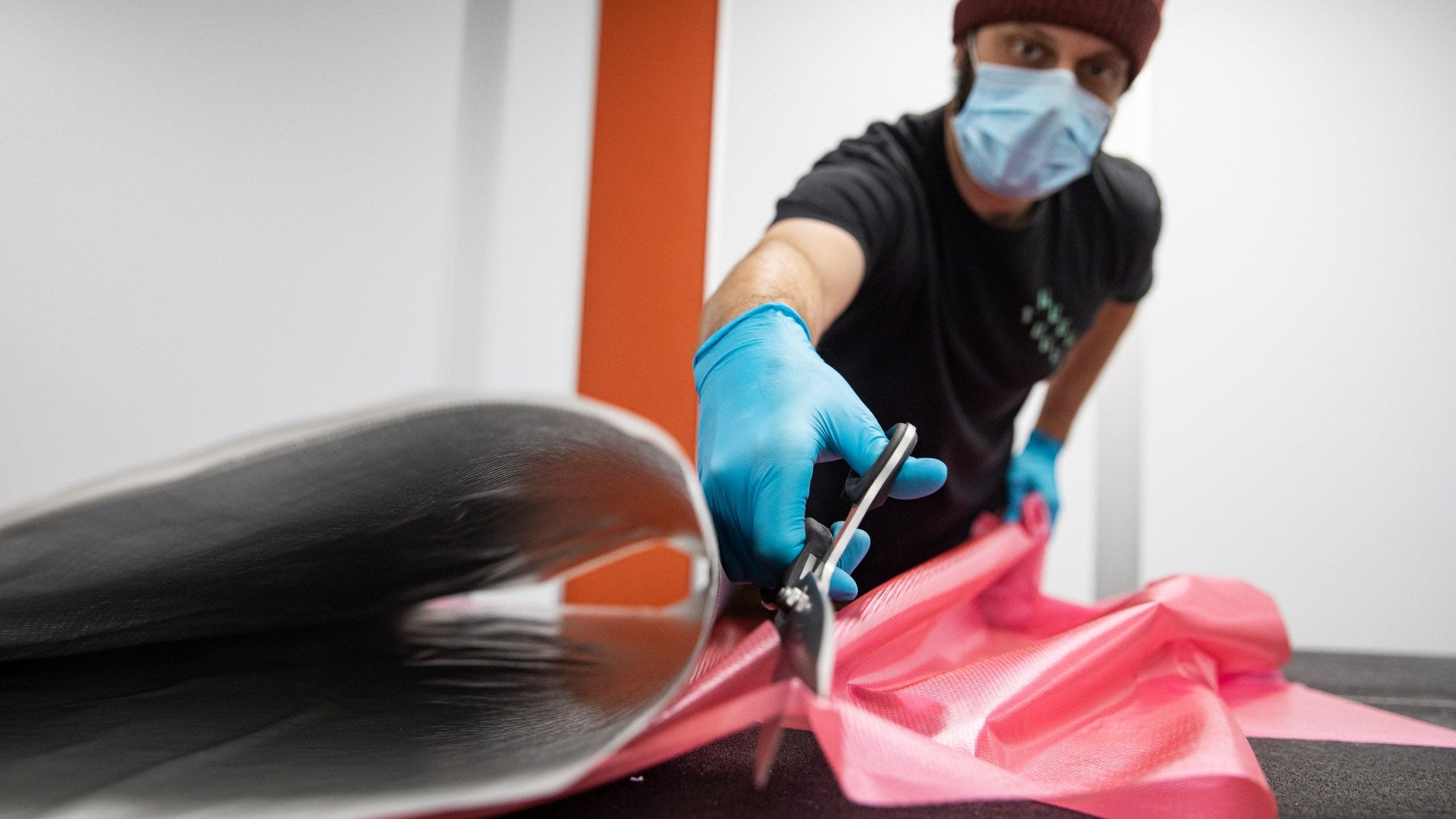 A worker cutting carbon fiber backing film.