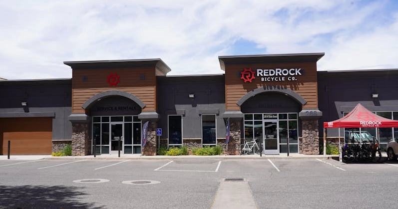 Red Rock Bicycle Co. storefront featuring a modern design with a branded red tent showcasing bikes outdoors