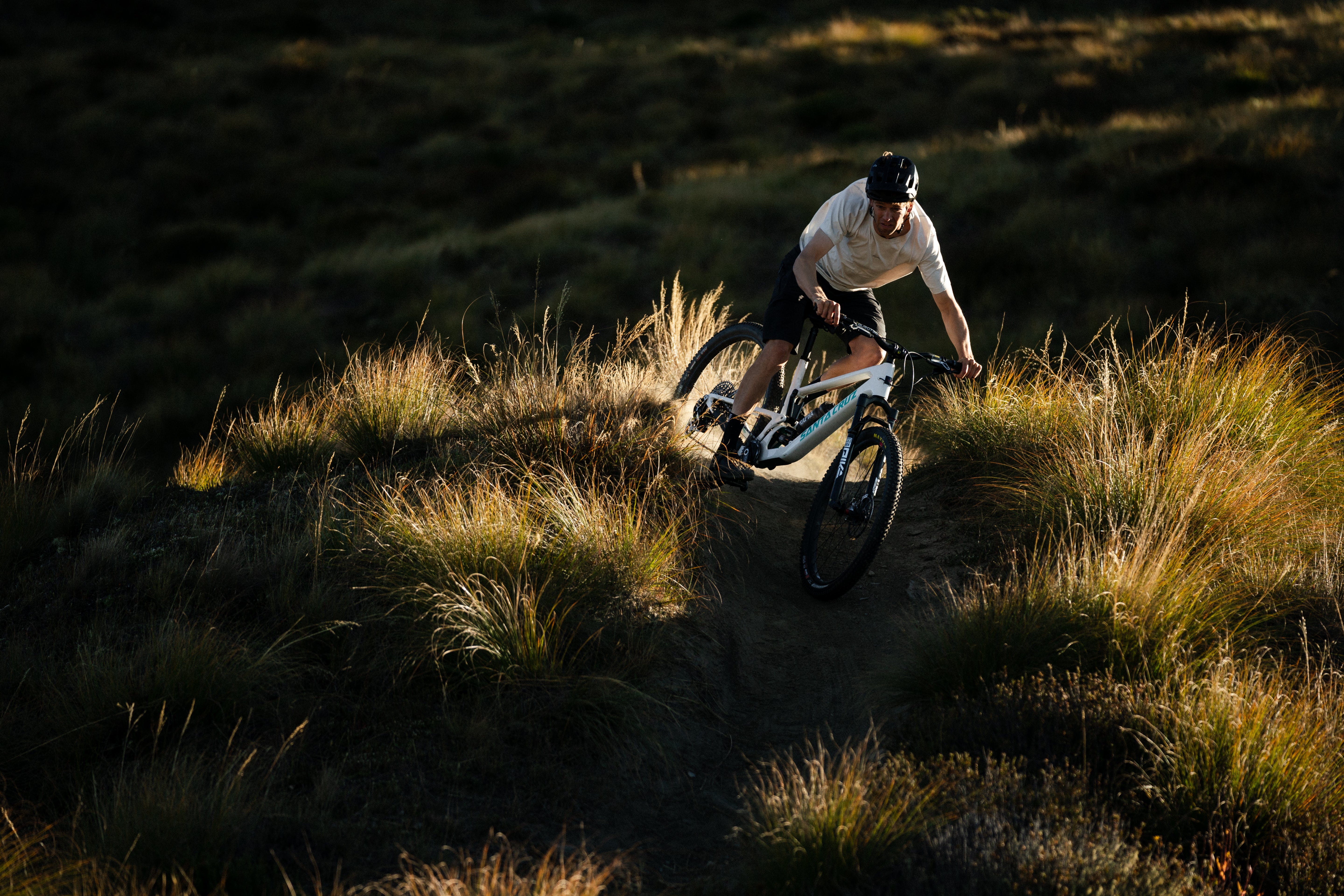 A rider on a Santa Cruz Tallboy descending through an open brushy landscape.