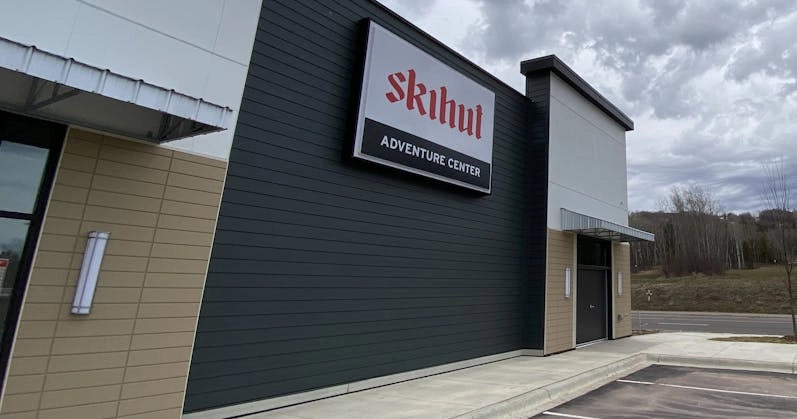 Exterior view of Ski Hut Adventure Center, featuring modern design and a prominent sign under cloudy skies