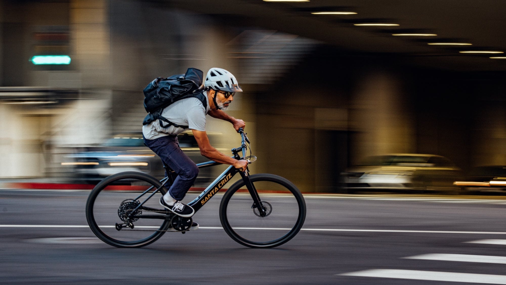 Man riding on a bike on a city street with backpack on 