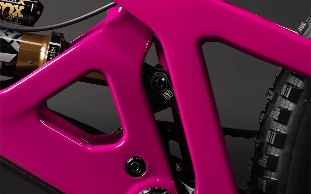 Close-up of a vibrant pink Santa Cruz bike frame showcasing the suspension linkage and rear triangle detail.