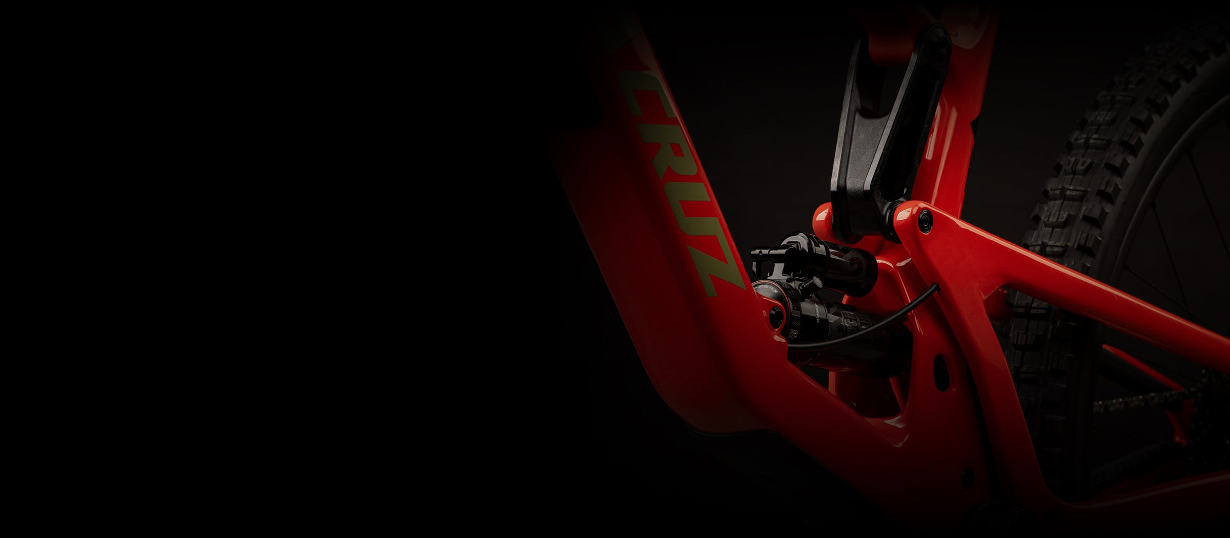 A close-up shot of a red Santa Cruz bike's rear suspension and frame, highlighting precision engineering