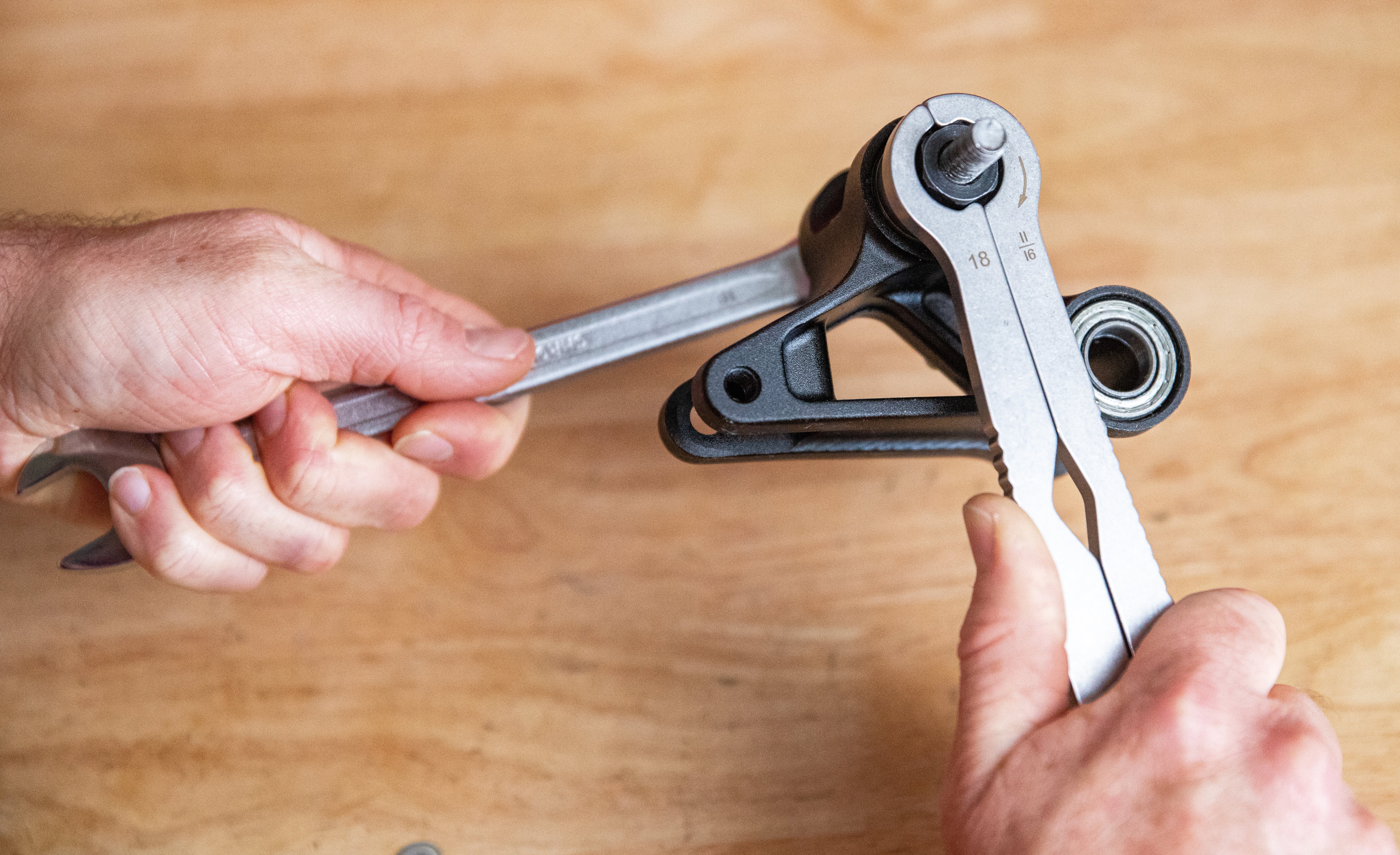 A mechanic installing new bearings on a lower linkage